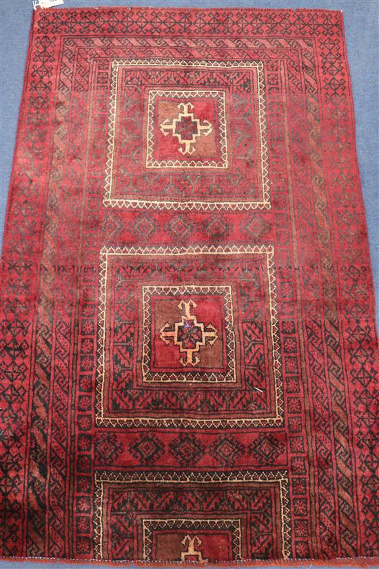 A Belouchi red ground rug, 4ft 11in by 2ft 1in.